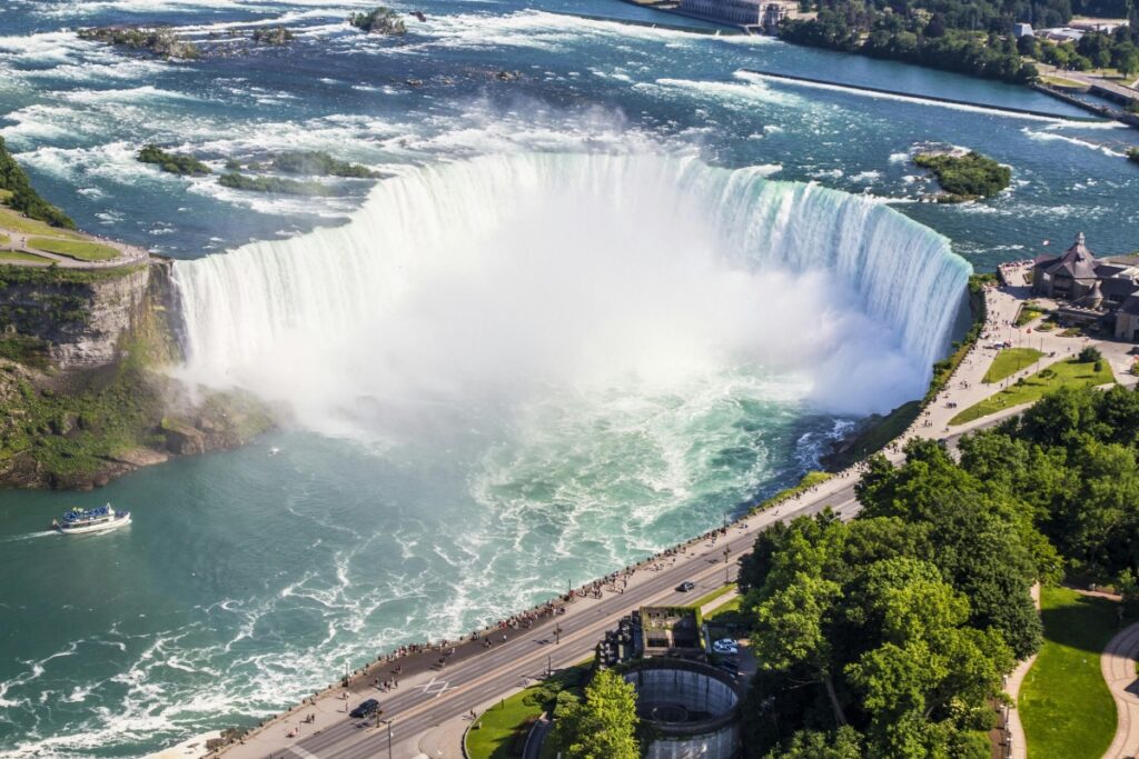 This aerial shot presents the awe - inspiring Niagara Falls, a world - famous natural wonder in Canada. The massive volume of water cascading down creates a spectacular mist, while boats filled with tourists navigate the swirling waters below. Alongside the falls, there are roads with vehicles and pedestrians, and patches of greenery. Regarding "LinkedIn Canada Top B2B Marketing Strategies for Professionals", if your business is related to tourism, hospitality, or event management in Canada, you can share images like this on LinkedIn. Highlight the potential for corporate events, team - building activities near the falls, or the unique experiences you can offer business clients in such a remarkable location. Use relevant hashtags such as #NiagaraFalls, #CanadianTourism, and #B2BMarketingCanada to reach out to professionals interested in these areas, thereby enhancing your B2B marketing efforts.