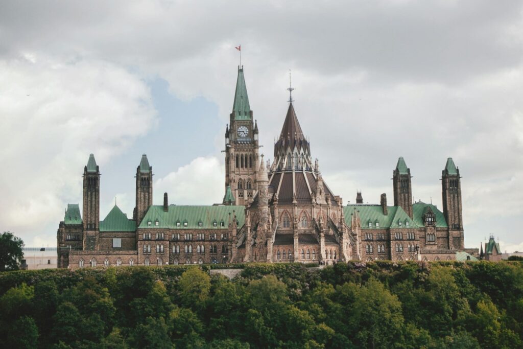 This image showcases the iconic Canadian Parliament Buildings in Ottawa. The Gothic - Revival architecture features a central clock tower, spires, and green - copper roofs, set against a cloudy sky and surrounded by lush greenery. When it comes to "TikTok Canada How to Create Viral Content and Gain Followers", content creators can film around historical and cultural landmarks like the Parliament Buildings. They could make videos highlighting the architecture, share fun facts about Canadian history and government, or even create engaging skits in the area. Using relevant hashtags such as #CanadianLandmarks, #Ottawa, and #CanadianHistory on TikTok can increase the visibility of the videos, attracting more viewers and helping to gain followers interested in Canadian culture and heritage.